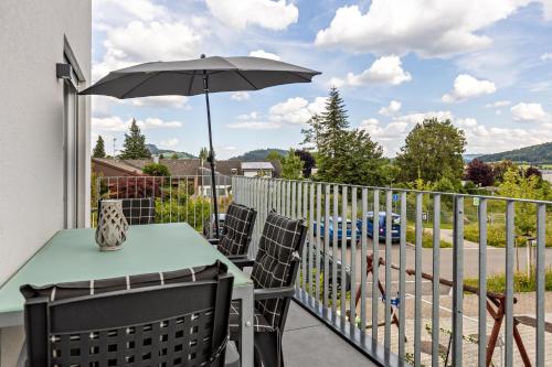 a balcony with a table and an umbrella at Schmuckstück in Hilzingen