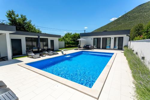 a swimming pool in the backyard of a house at Holiday Home Noa in Mostar