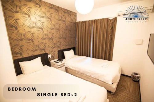 a room with two beds in a hotel room at アナザースカイ京都二条城 in Kinugasa