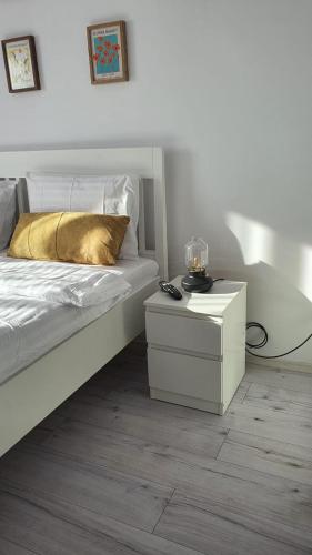 a bedroom with a bed and a table with a gold pillow at La Ana Apartament in Şelimbăr