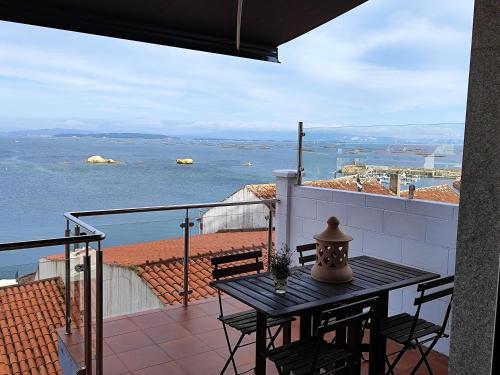 a table on a balcony with a view of the water at Casa Boa Vista in San Pedro