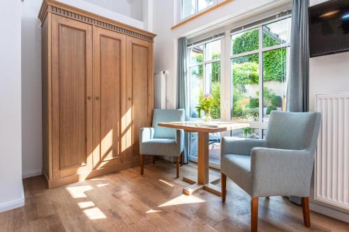 a dining room with a table and chairs and a window at Apartments an Sankt Marien in Stralsund