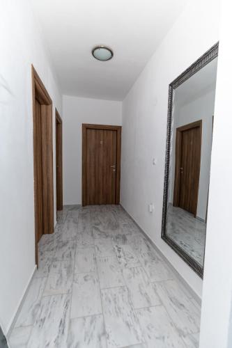 a hallway with a mirror and white walls at Villa Olympia in Paralia Katerinis