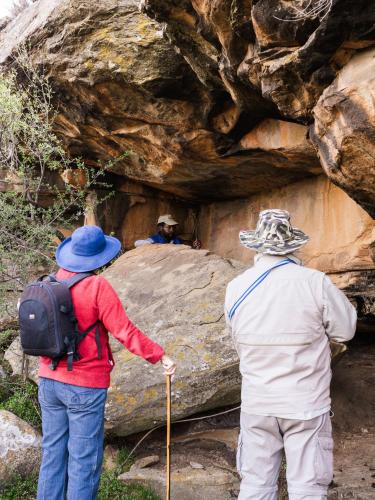 two people standing in front of a cave at Ganora Guest Farm, Camping and Excursions in Nieu-Bethesda