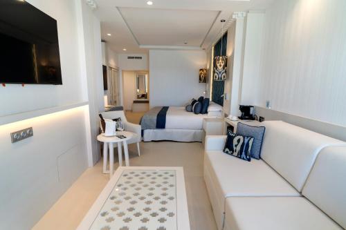 a hotel room with two beds and a couch at Nixe Palace in Palma de Mallorca
