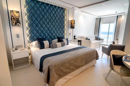 a bedroom with a large bed with a blue headboard at Nixe Palace in Palma de Mallorca