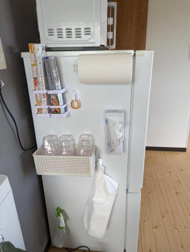 a white refrigerator with a microwave on top of it at 海辺の宿錦 a in Tomakomai