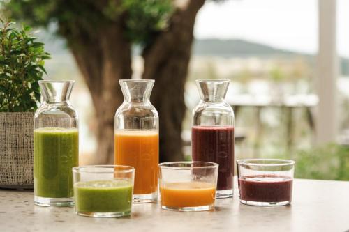 a group of four glass bottles with different colored liquids at Thetis Boutique Apartments in Neos Marmaras