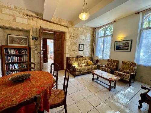 a large living room with a table and chairs at Le Doyenné, hotel particulier centre ancien de Tarascon in Tarascon