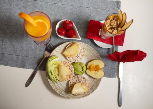 um prato de comida com fruta e um copo de sumo de laranja em Hotel Zeus em Pomorie