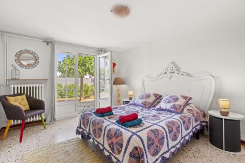 een slaapkamer met een bed, een stoel en een raam bij Appartement La Marina in Fréjus