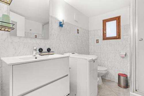 een witte badkamer met een wastafel en een toilet bij Appartement La Marina in Fréjus