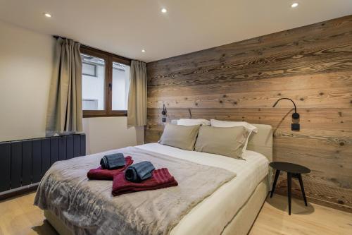 - une chambre avec un grand lit et des murs en bois dans l'établissement Chalet Claudia by Brennus Chamonix, à Chamonix-Mont-Blanc