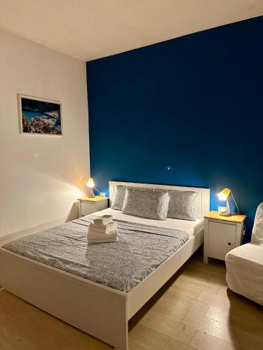 a bedroom with a large bed with a blue wall at Romulea Guest House in Rome