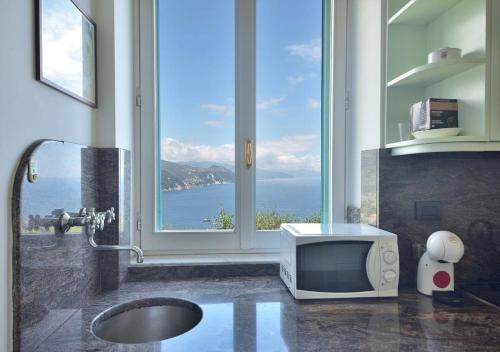 a bathroom with a television on a counter with a window at Andromeda Flexyrent in Rapallo