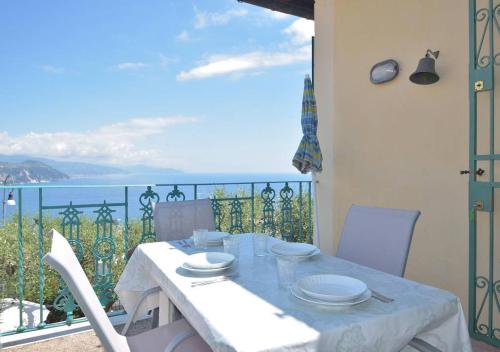 a table with white plates on it on a balcony at Andromeda Flexyrent in Rapallo