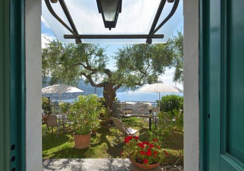 a door leading to a patio with chairs and umbrellas at Andromeda Flexyrent in Rapallo