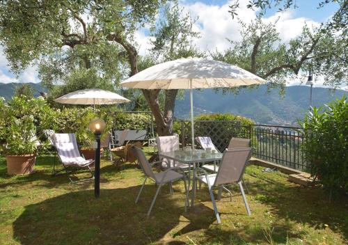 a table and chairs under an umbrella on a patio at Andromeda Flexyrent in Rapallo