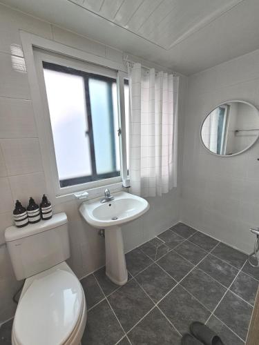 a bathroom with a toilet and a sink and a window at OMG house in Seoul