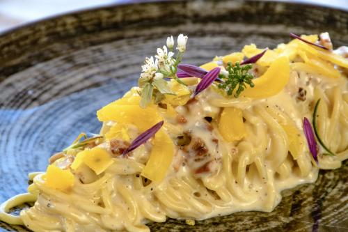 a plate of pasta with onions and herbs at Hotel Barbagia in Dorgali