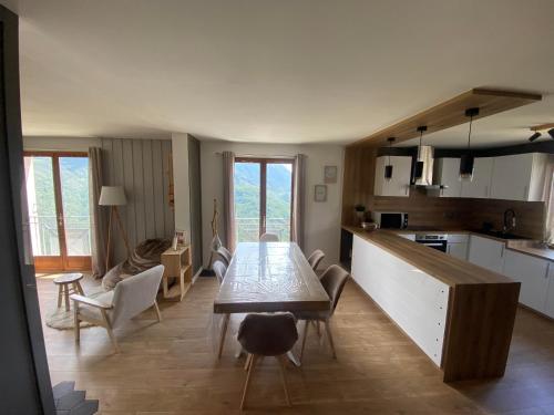 une cuisine et un salon avec une table et des chaises dans l'établissement Grande Maison Vue Montagne au calme, à Rimplas