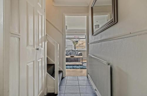 a hallway with a door and a mirror and a chair at Spacious 4 Bedroom House private parking in Cottingham