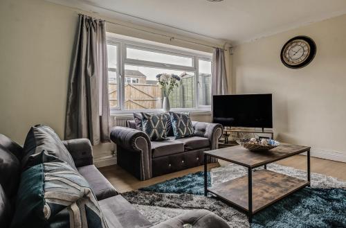 a living room with a couch and a tv at Spacious 4 Bedroom House private parking in Cottingham