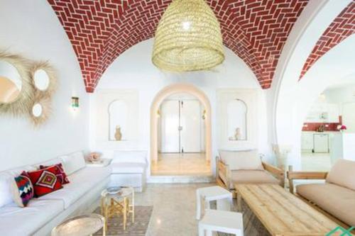 a living room with a couch and a chandelier at Dar Barsha: Beach front white sand and happiness in Rafrāf