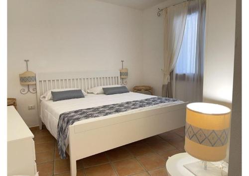 a bedroom with a large white bed in a room at Le Residenze sul mare B6 in Porto Ottiolu