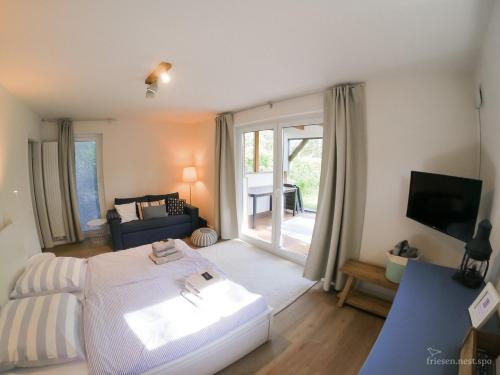 a bedroom with a white bed and a living room at friesen-nest-spo in Böhl