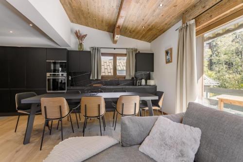 une cuisine et un salon avec une table et des chaises dans l'établissement Chalet Marguerite by Brennus Chamonix, à Chamonix-Mont-Blanc