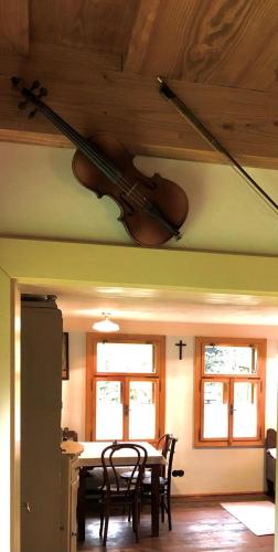 a violin hanging from the ceiling of a room with a table at Chalupy Pod Šenkem - Výminek in Vsetín