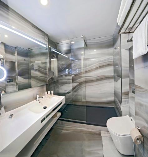 a bathroom with a sink and a toilet at Mercure Paris Nanterre in Nanterre