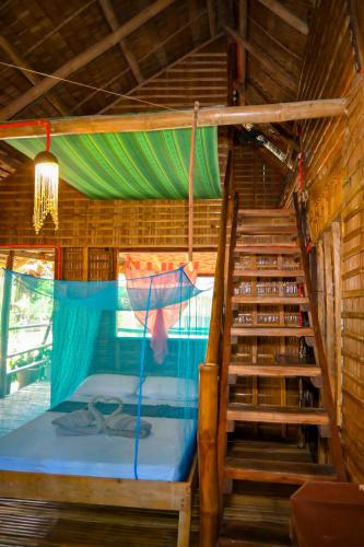 a room with a bunk bed and a staircase at Driftwood Village Resort in Sipalay
