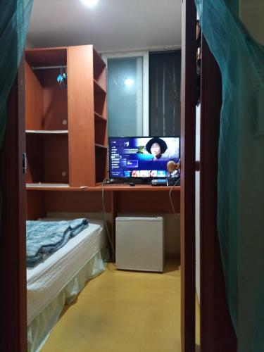 a bedroom with a tv on a desk with a bed at Mokhwatel in Busan