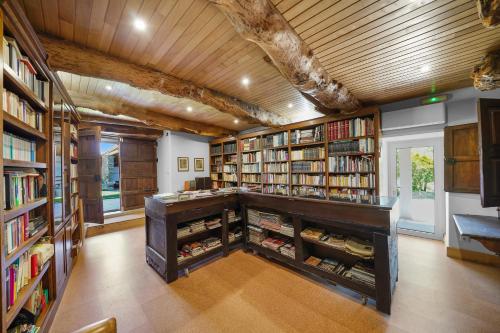 a library with bookshelves and a desk with books at Casa da Edrosa in Edrosa