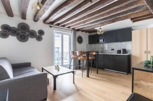 un salon avec un canapé et une cuisine dans l'établissement Grands Boulevard 31 Appartement Cosy 3D, à Paris
