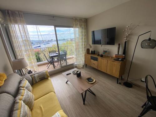 un salon avec un canapé et une grande fenêtre dans l'établissement Sol-y-Days Santa Maria vue sur les marinas, au Grau-du-Roi