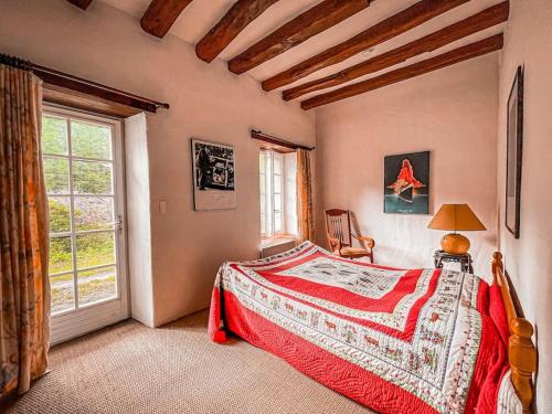 une chambre avec un lit et une grande fenêtre dans l'établissement Moulin de la Caluyére, à Ardenay-sur-Mérize