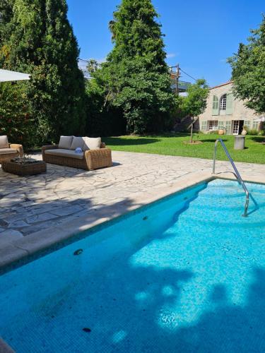 - une piscine avec un canapé et un parasol dans l'établissement Mas de charme avec piscine, à Antibes