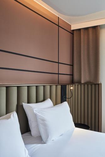 a bedroom with a bed with white pillows at Mercure Paris Nanterre in Nanterre