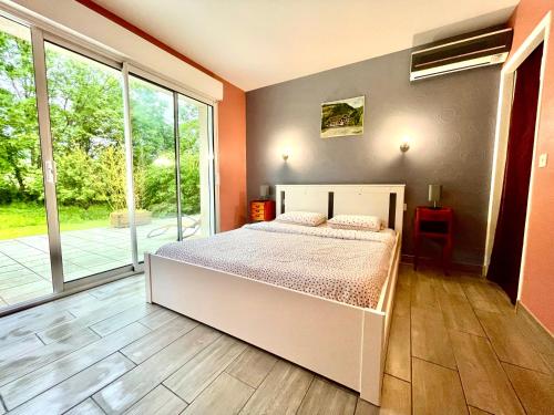 une chambre avec un lit et une grande fenêtre dans l'établissement Chez Coccinelle, à Marmagne