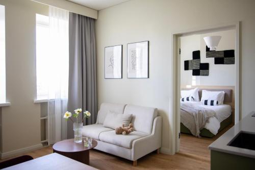 a living room with a white chair and a bed at Bob W Turku City Centre in Turku