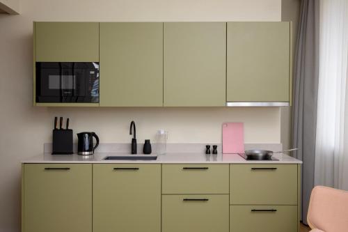 a kitchen with white cabinets and a sink at Bob W Turku City Centre in Turku