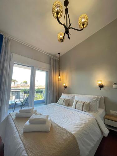 a bedroom with a large white bed with towels on it at Gaia Apartments in Hanioti