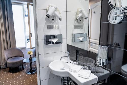 a bathroom with a sink and a mirror at Hotel de la Paix Tour Eiffel in Paris