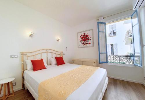 une chambre avec un lit avec des oreillers rouges et une fenêtre dans l'établissement Nestor&Jeeves - BRISE DE NICE - Balcony - Central, à Nice