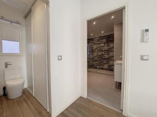 La salle de bains est pourvue de toilettes et d'un mur en pierre. dans l'établissement Nestor&Jeeves - BRISE DE NICE - Balcony - Central, à Nice