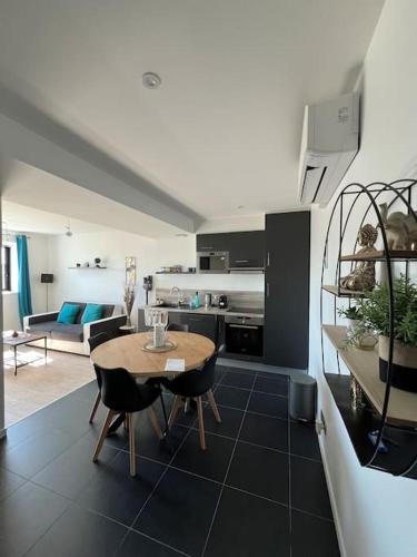 une cuisine et un salon avec une table et des chaises dans l'établissement JOIA Bassin d'Arcachon - LE ROOF 268, à La Teste-de-Buch