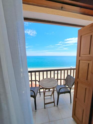 a balcony with a table and chairs and the ocean at Akrogiali in Agios Ioannis Pelio